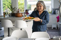 Senior woman carrying lunch in dining room