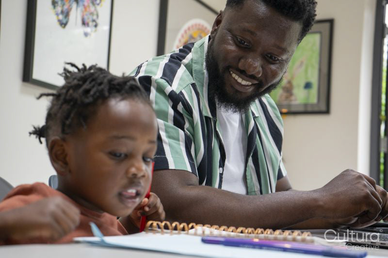 Father looking at daughter drawing in notepad