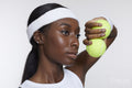 Studio portrait of athletic woman with tennis balls