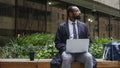 Business man sitting on bench and using laptop