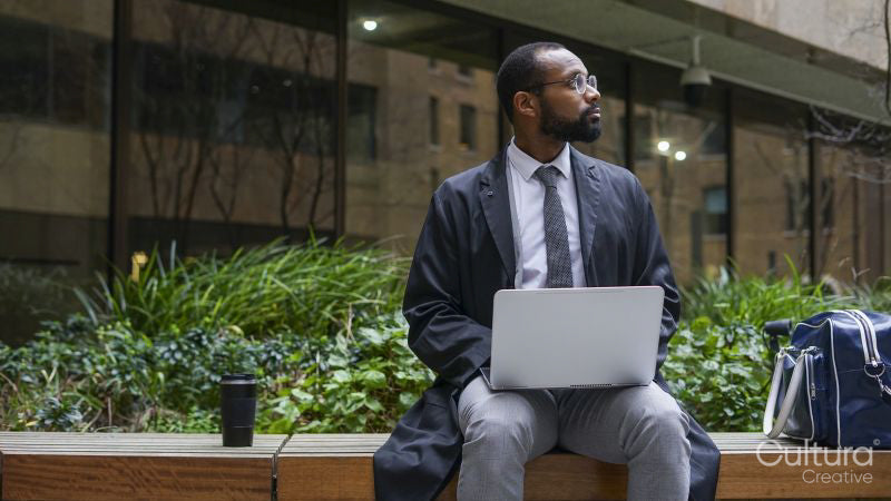 Business man sitting on bench and using laptop