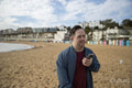 Mid adult man on beach, holding phone