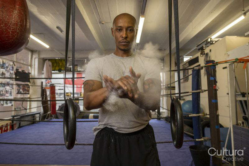 Mature man rubbing hands in gym