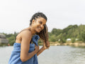 Smiling woman standing wrapped in towel by lake