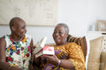 Smiling woman giving gift to mother at home