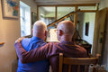 Senior male couple playing piano at home