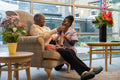 Smiling nurse looking at senior woman knitting in nursing home