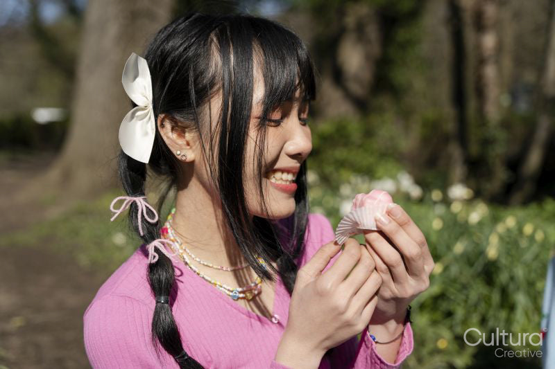 Smiling young woman eating dessert in park