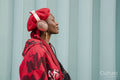 Smiling young woman wearing red listening to music