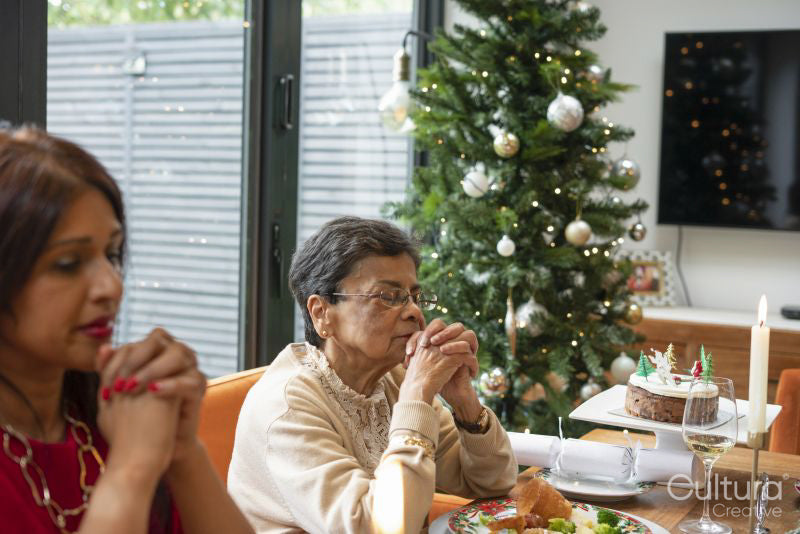 Women praying during Christmas dinner