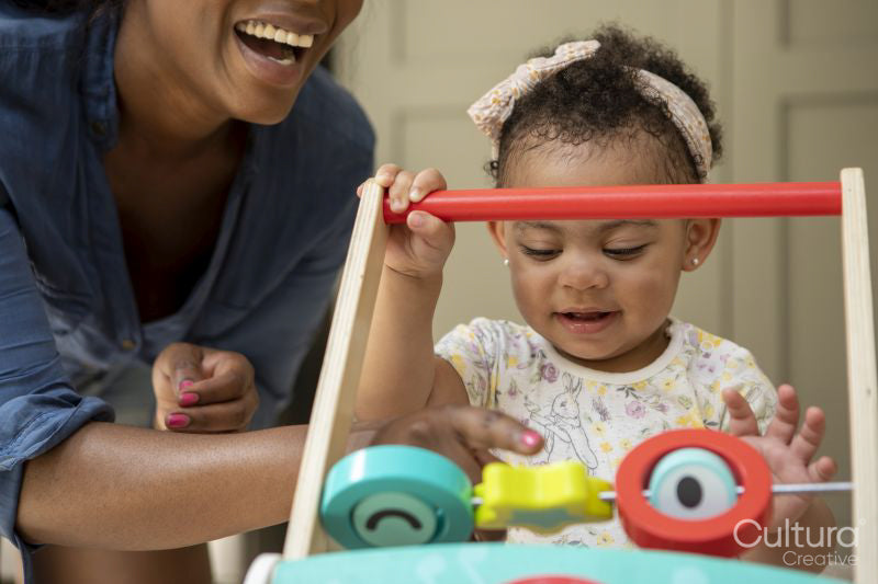 Mother playing with baby daughter at home