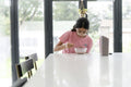 Girl eating breakfast at table in living room
