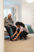 Nurse helping senior man to get dressed at nursing home