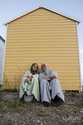 Two Muslim friends sitting by beach hut