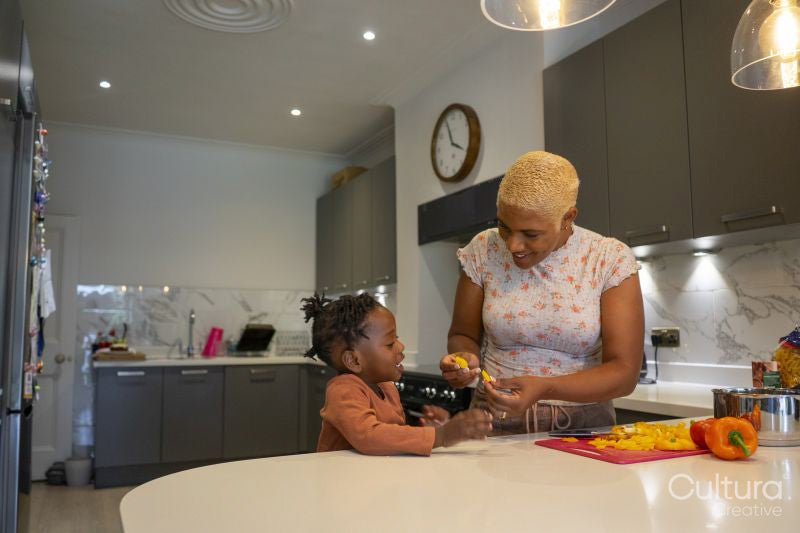 Mother and daughter preparing food in kitchen