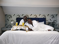 Mature couple enjoying breakfast on bed in hotel room