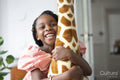 Smiling girl hugging toy giraffe