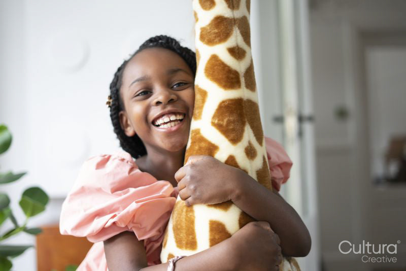 Smiling girl hugging toy giraffe