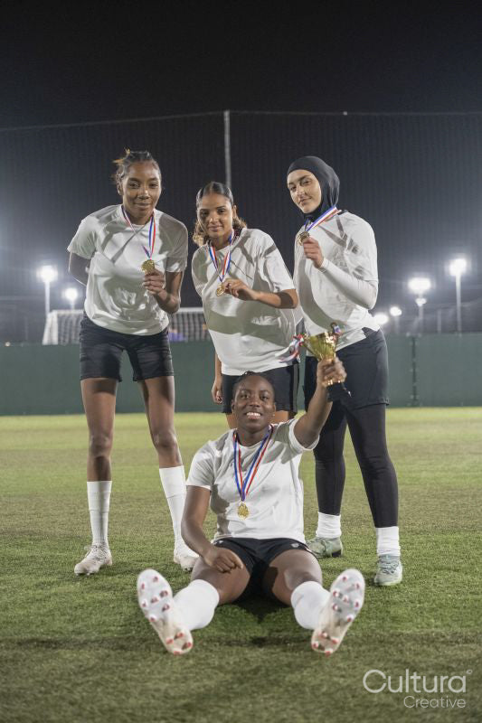 Team of female soccer players celebrating victory