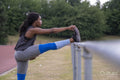 Athletic woman stretching leg on running track
