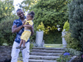 Father carrying son in garden