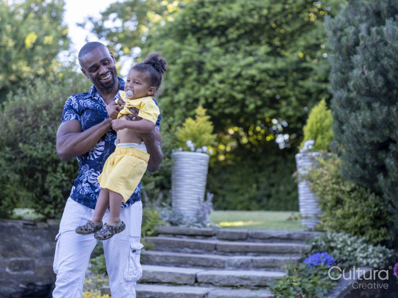 Father carrying son in garden