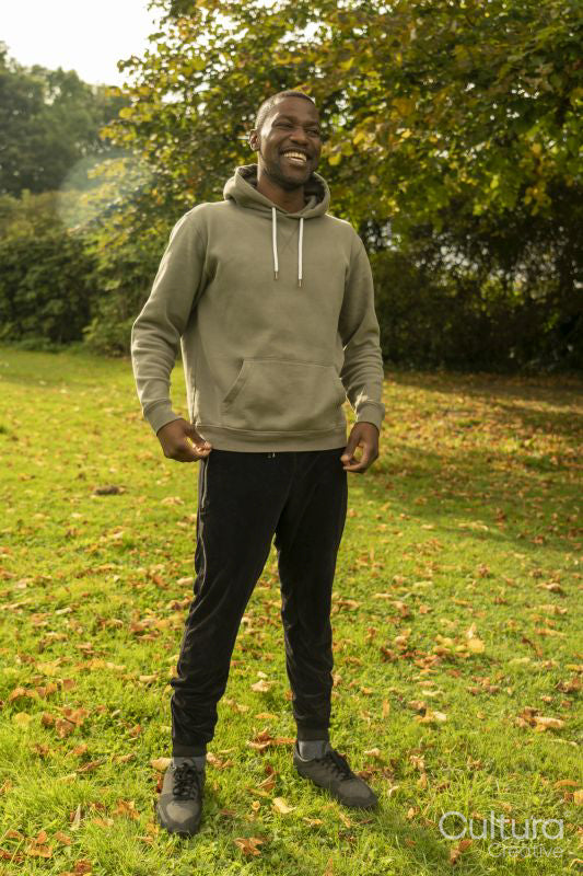 Smiling man standing on lawn in park in autumn