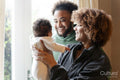 Smiling parents looking at baby daughter at home