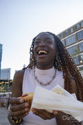 Laughing young woman holding hot dog