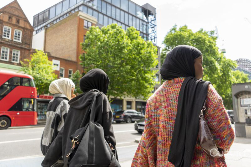 Rear view of young women wearing hijabs walking in city
