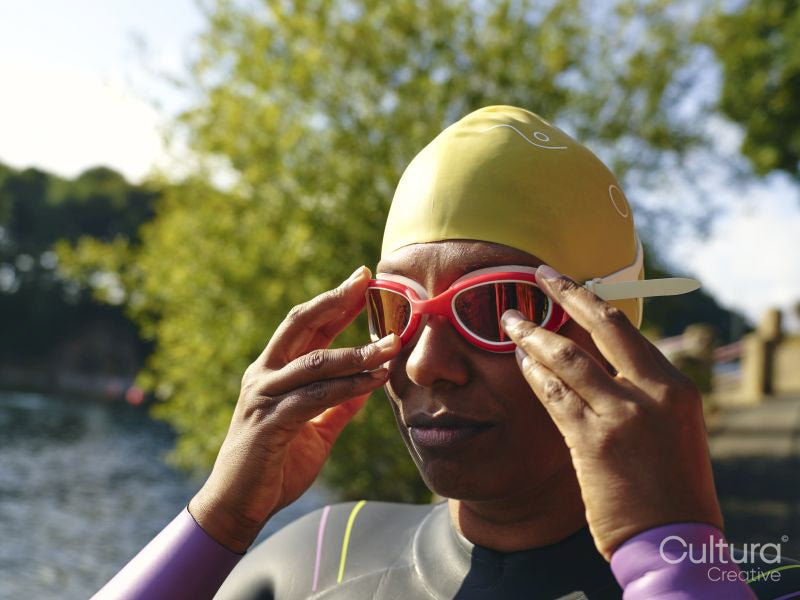 Woman putting on swimming goggles