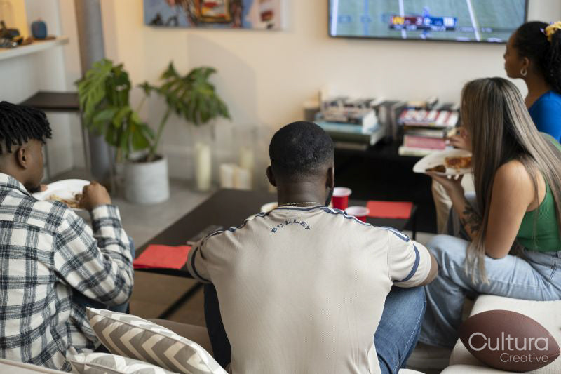 Friends watching American football on TV at home