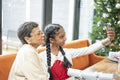 Smiling girl with grandmother taking selfie at table