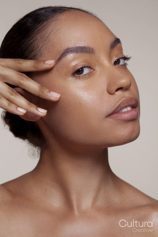 Portrait of young woman touching face