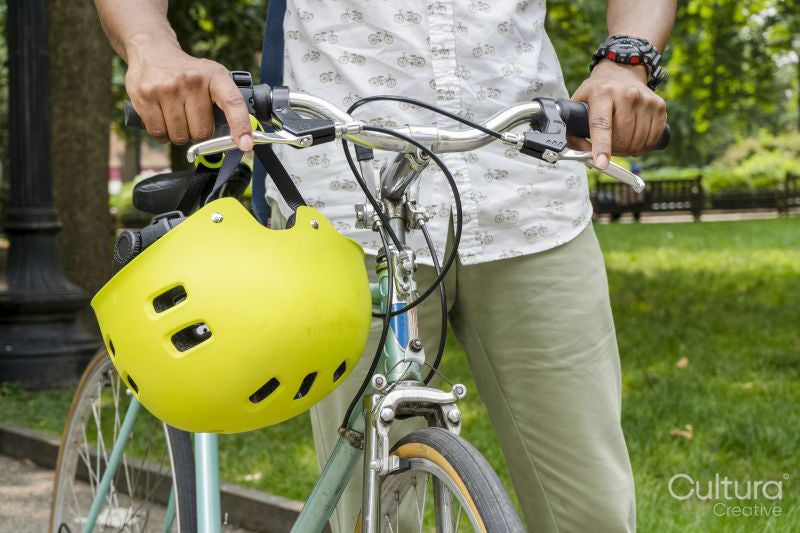 Man with bicycle standing in park, mid section