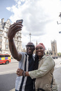 Happy mature couple taking selfie while visiting city