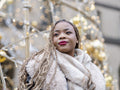 Young woman standing against Christmas decorations