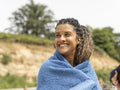 Portrait of smiling woman wrapped in towel on beach