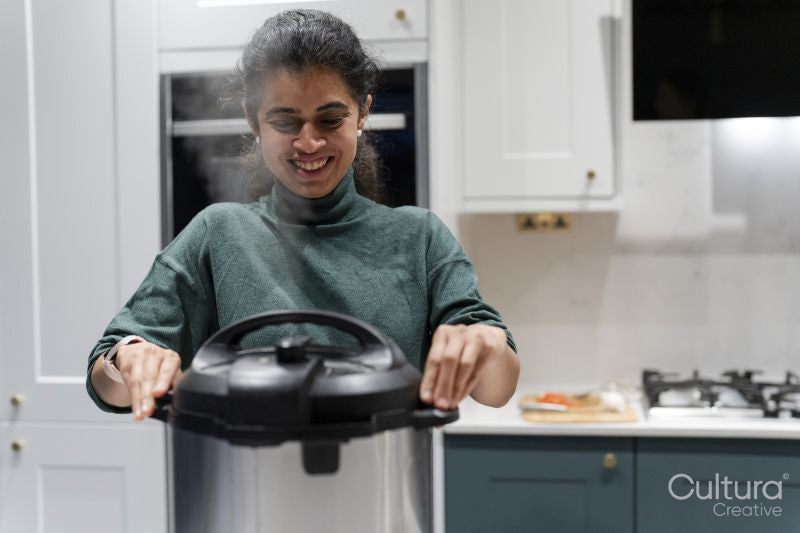 Woman opening pressure cooker pot in kitchen