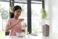 Girl eating breakfast at table in living room