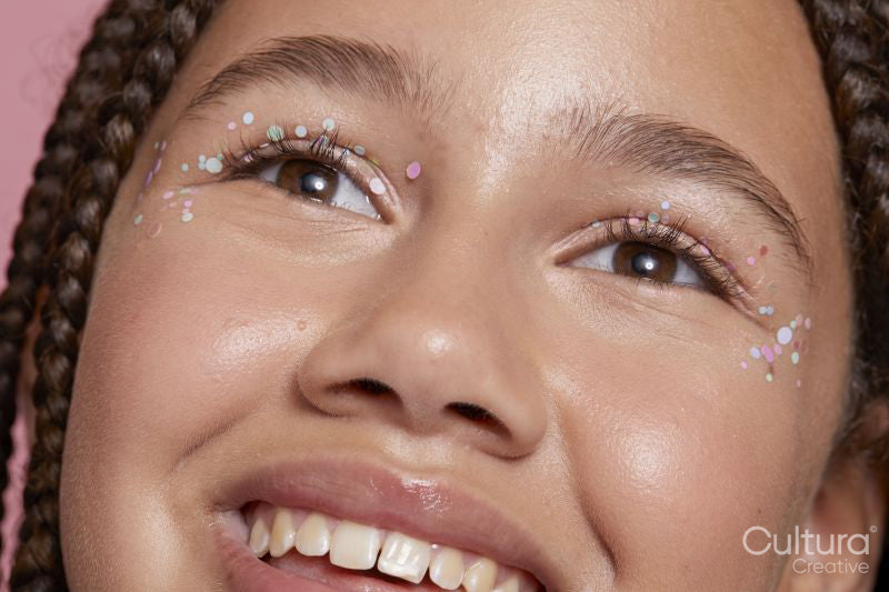 Close-up of smiling girl with decorative stickers on face