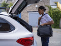 Nurse preparing to drive car, opening trunk