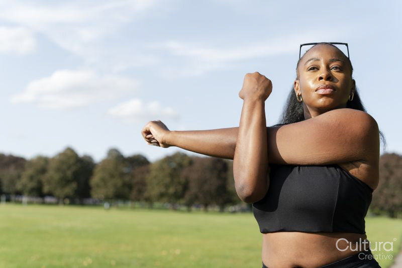 Young woman stretching in park