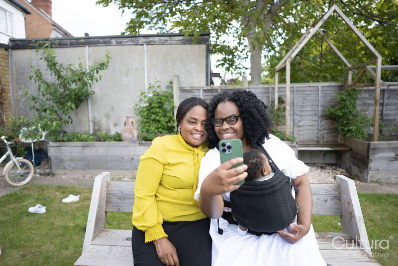 Grandmother with adult daughter and baby grandson taking selfie