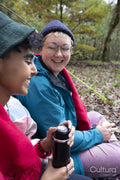 Smiling female friends camping in forest
