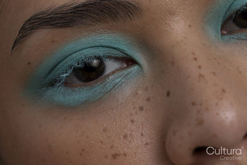 Close-up of woman wearing blue makeup