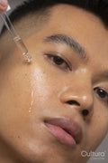 Close-up of person applying serum on face