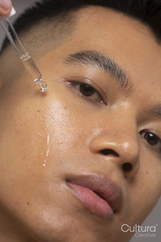 Close-up of person applying serum on face