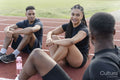 Group of athletes resting at sports track after training