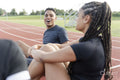 Couple of athletes resting at sports track after training